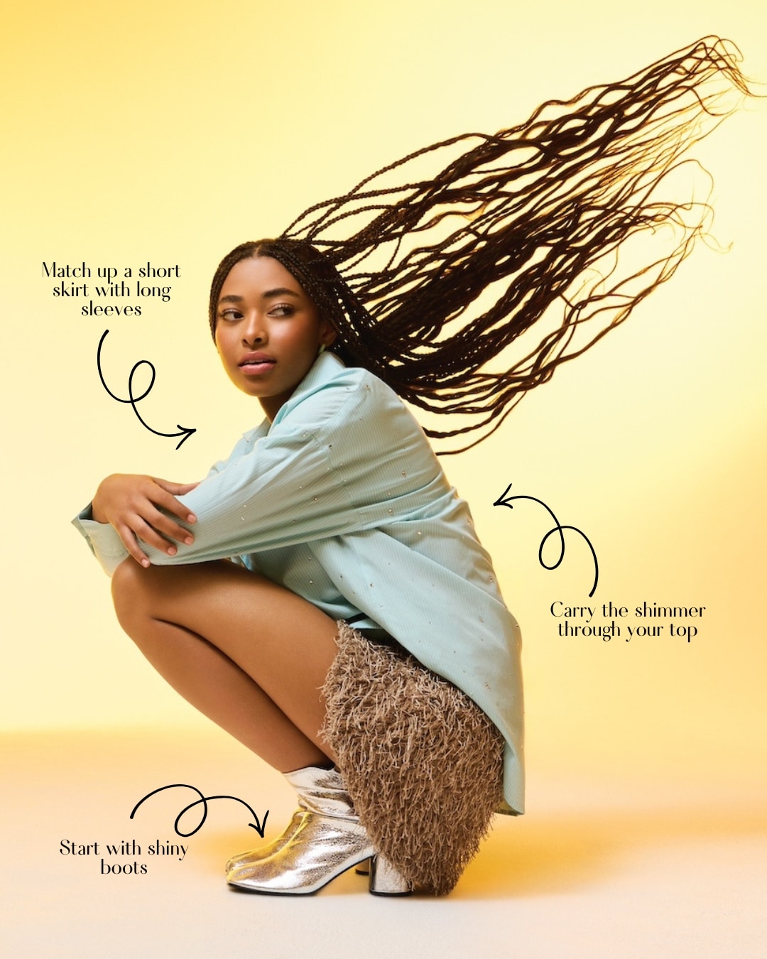 A woman with long braids poses in a squat against a yellow background, showcasing a perfect spring outfit in a light blue long-sleeve shirt, textured short skirt, and shiny silver boots. Style guide tips with arrows highlight her chic look.