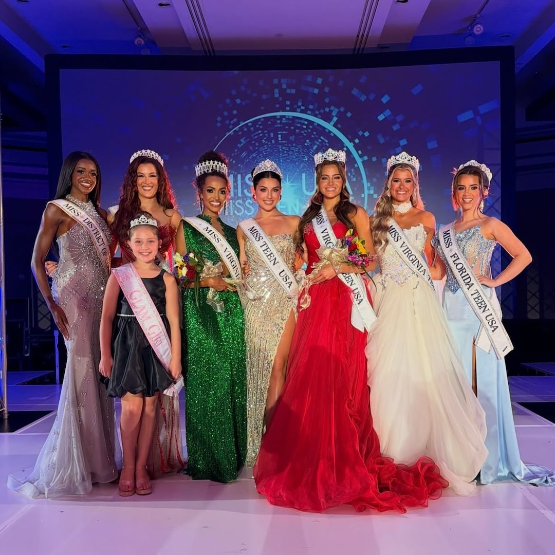 Seven pageant winners in gowns and sashes stand on stage with crowns, smiling, along with a young girl in a sash and crown. A colorful digital backdrop is visible behind them.