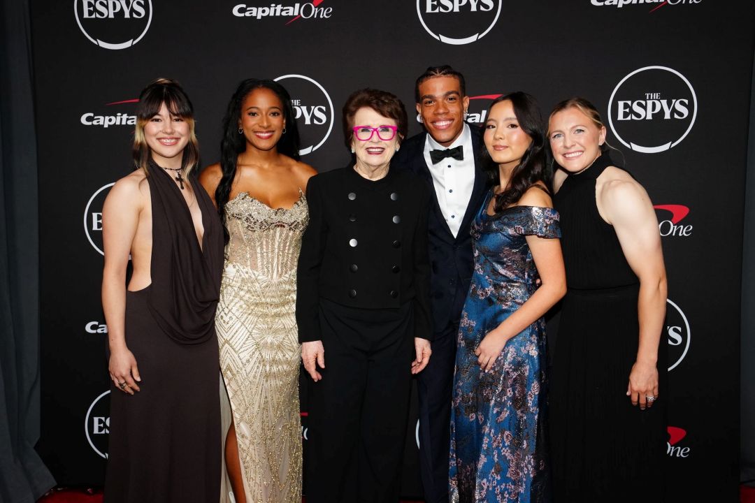 Six people stand together smiling on the ESPYS red carpet, celebrating their biggest win, dressed in formal evening wear. Among them is Julia Howe, all posing before a black backdrop featuring ESPY Award and Capital One logos.